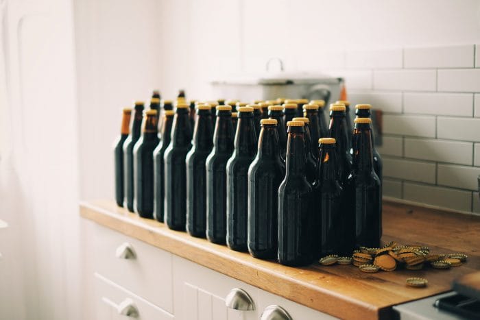 bottles of stout sit on a metro tiled kitchen worktop