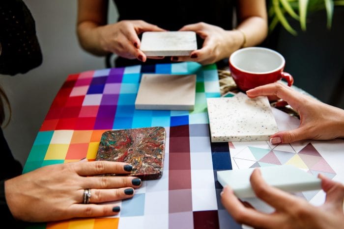 women holding tiles on colourful table