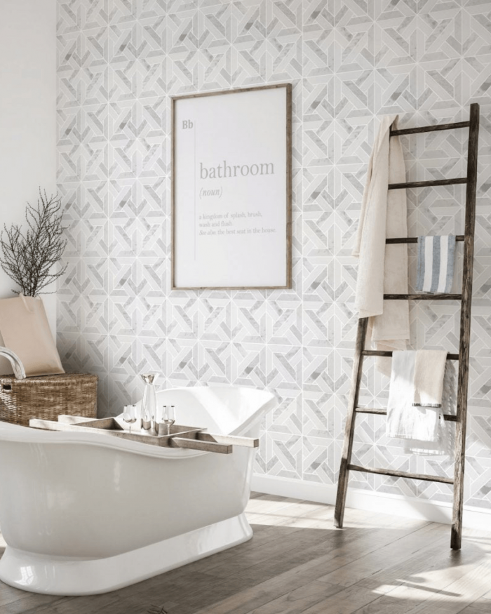 Marble patterned tiles styled with a bath and wooden towel ladder